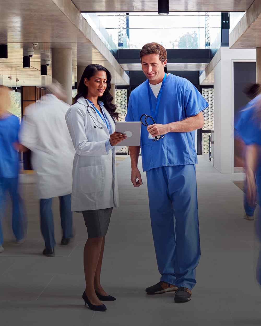 Foot & ankle specialist in scrub standing in a hospital corridor.